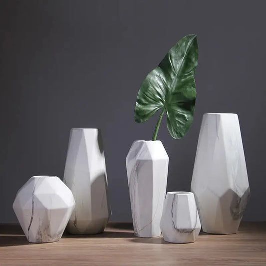 a group of white vases sitting on top of a wooden table