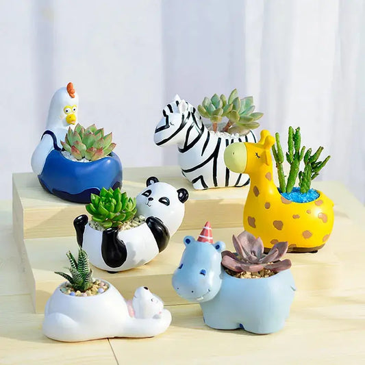 a group of ceramic animals sitting on top of a wooden table