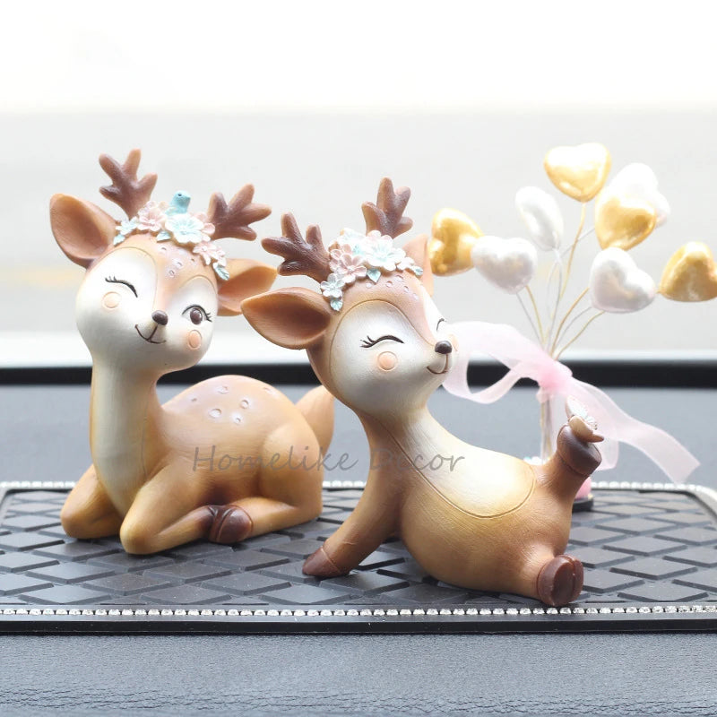 a couple of deer figurines sitting on top of a table