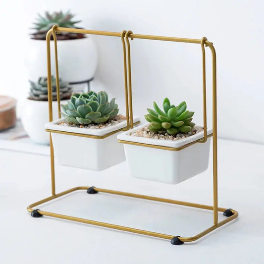 a pair of white planters sitting on top of a metal stand