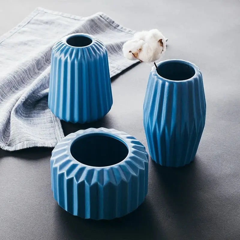three blue vases sitting on top of a table