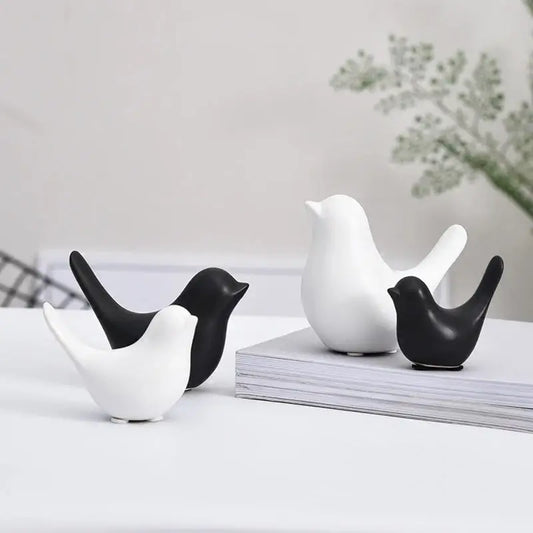 a couple of black and white birds sitting on top of a table