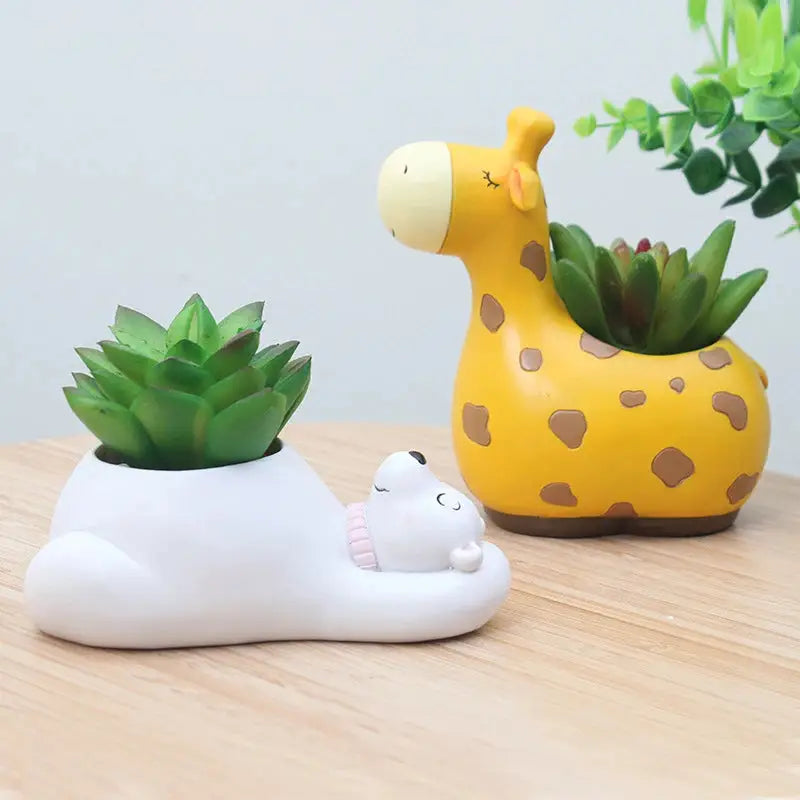 a ceramic giraffe planter sitting next to a ceramic cat