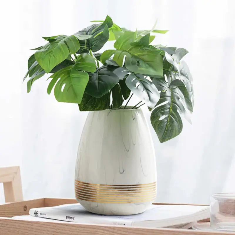 a plant in a white vase on a table