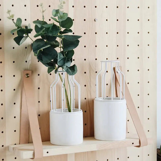a couple of white vases sitting on top of a wooden shelf
