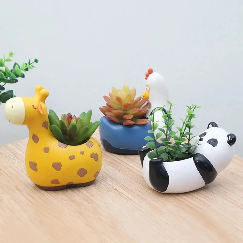 a group of three ceramic animals sitting on top of a wooden table