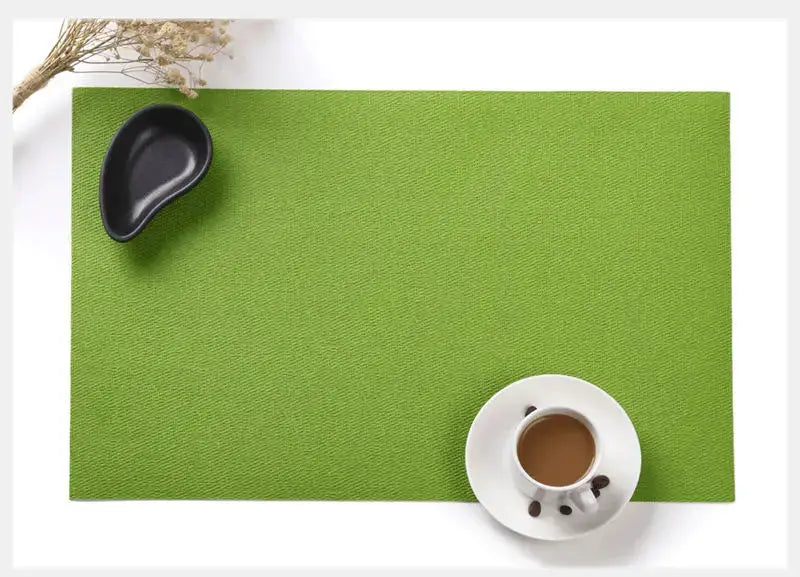 a cup of coffee sitting on top of a green mat