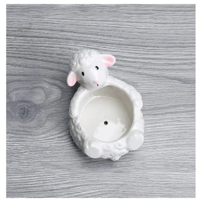 a sheep shaped candle holder sitting on top of a wooden table