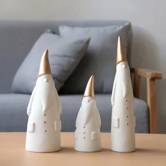 three white ceramic figurines sitting on a table