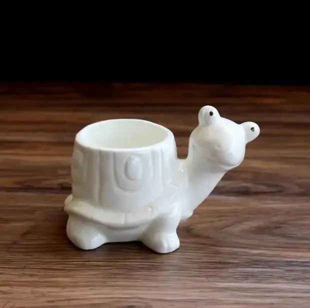 a white ceramic camel shaped cup on a wooden table