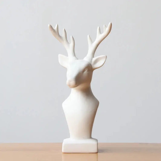 a white ceramic deer head on a wooden table