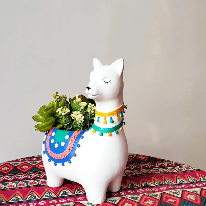 a white llama planter sitting on top of a table