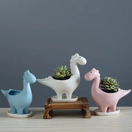 three ceramic dinosaurs with succulents in them