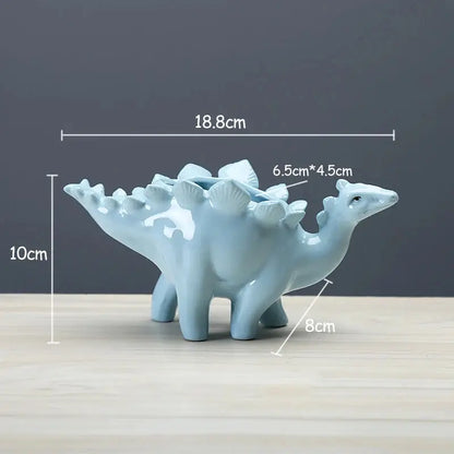 a blue ceramic dinosaur planter sitting on top of a wooden table