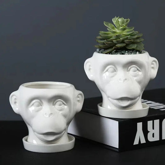a white planter with a monkey face on it
