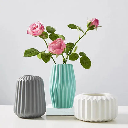 three vases with flowers in them on a table
