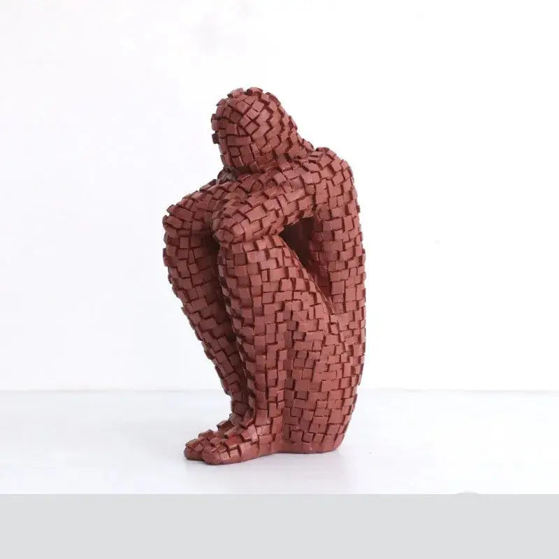 a sculpture of a person sitting on a white surface
