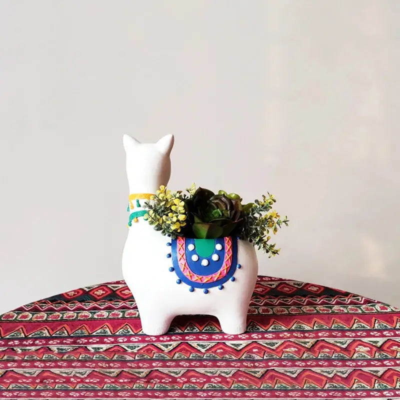 a white llama planter with a succulent plant in it