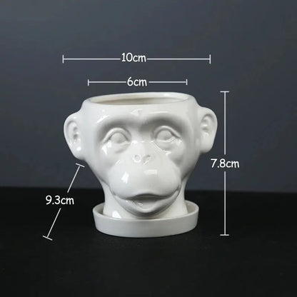 a white ceramic monkey head planter on a table