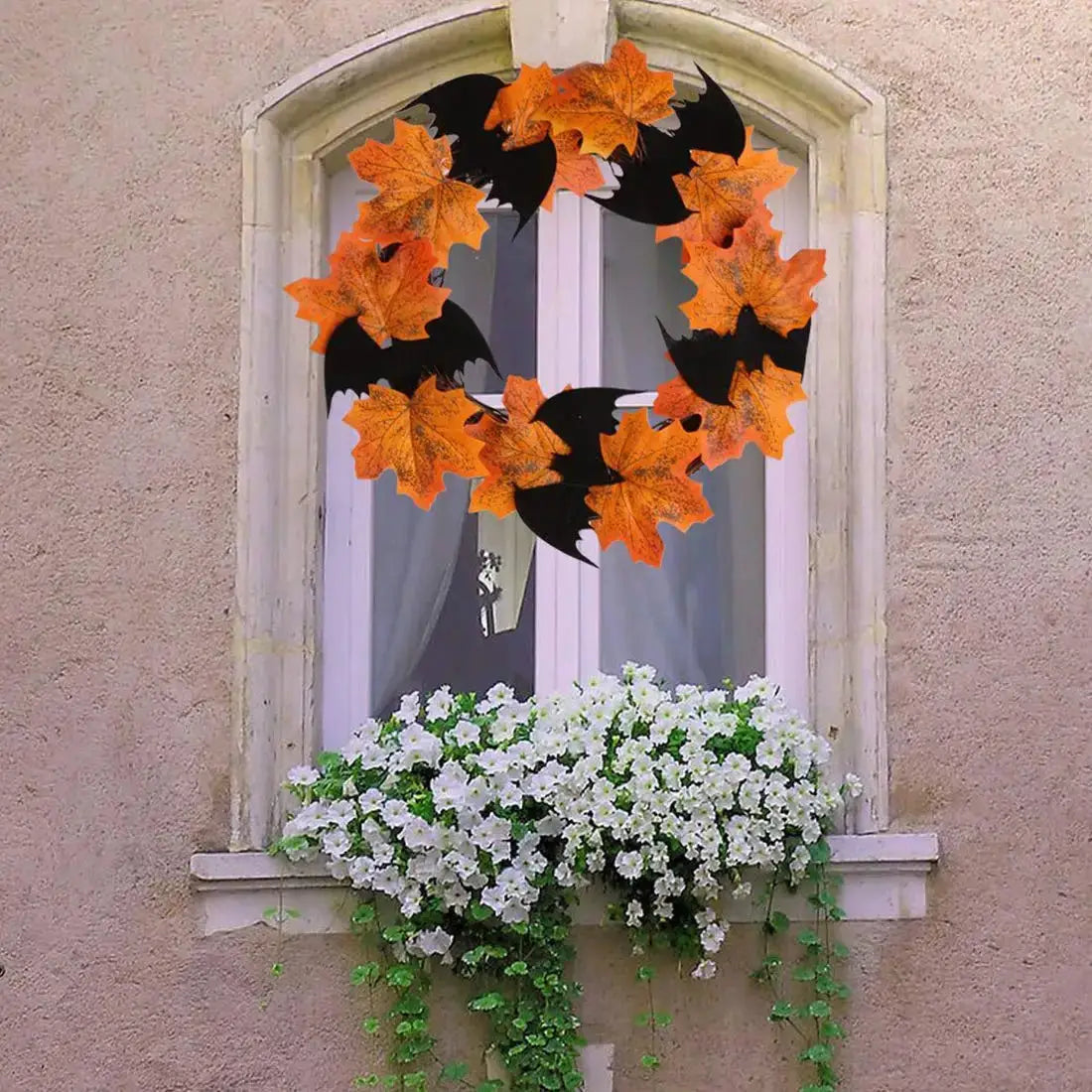 a window with a wreath of leaves and flowers on it
