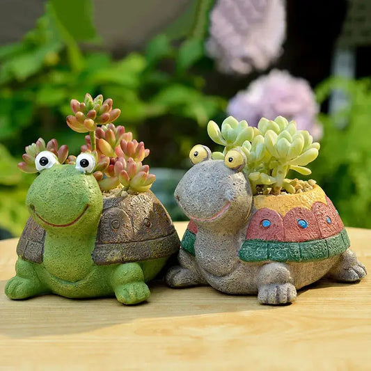 a couple of small turtle planters sitting on top of a wooden table