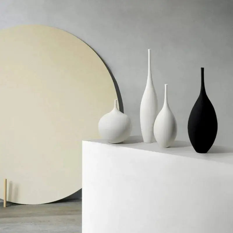 three white and black vases sitting on a table