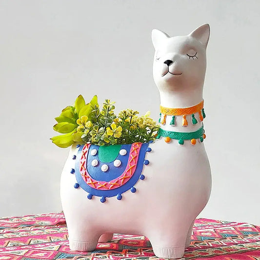 a ceramic cat with a flower pot on top of it