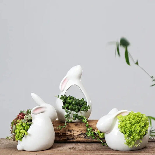 a wooden table topped with three white rabbits