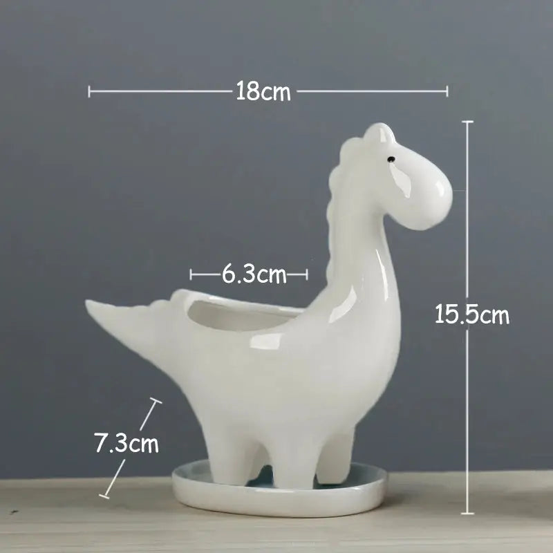 a white ceramic llama planter on a table