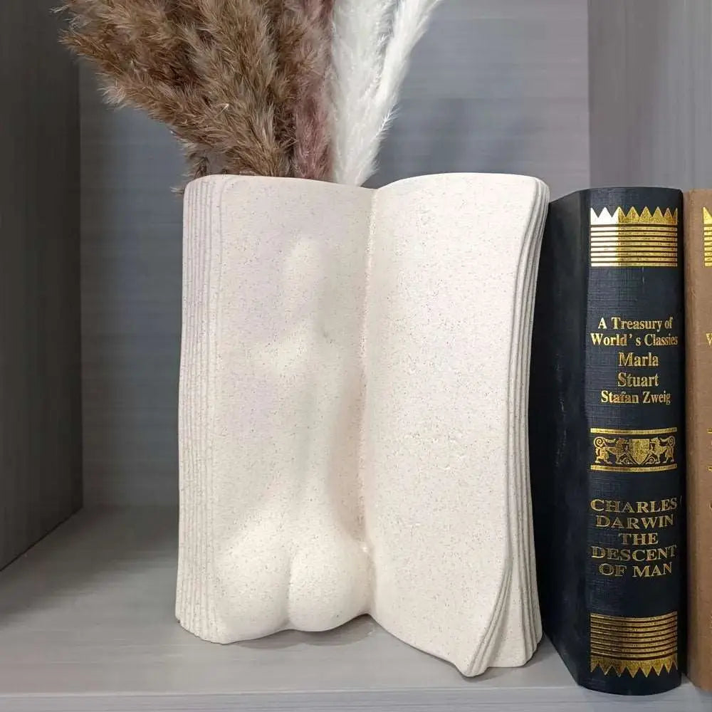 a book and a feather sit on a shelf