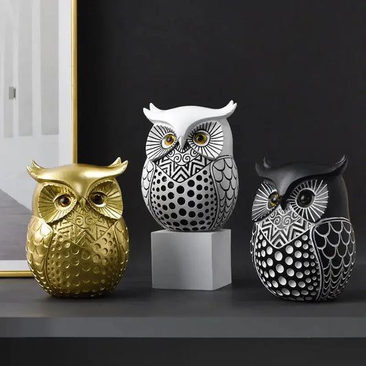 three decorative owls sitting on a shelf next to a mirror