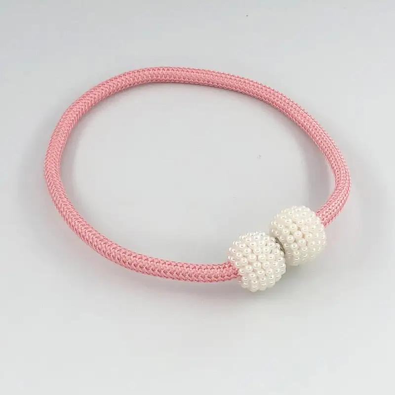 a pink and white bracelet with two beads