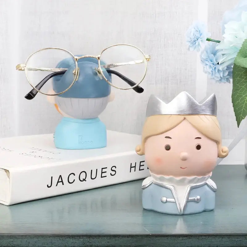 a book with glasses on top of it next to a figurine of a