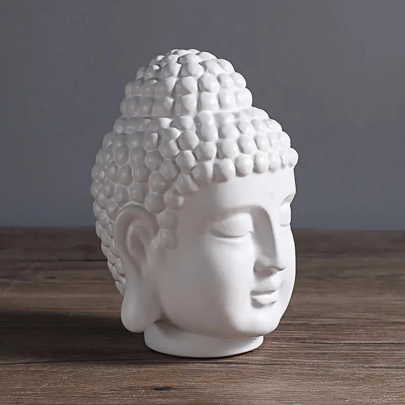 a white buddha head sitting on top of a wooden table