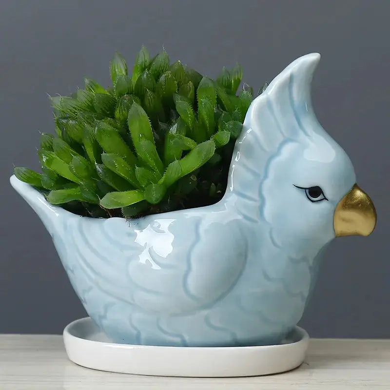 a ceramic bird planter with a plant in it