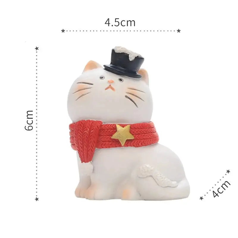 a white cat figurine with a hat and scarf