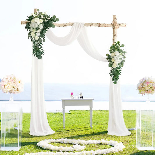 an outdoor ceremony setup with white flowers and greenery