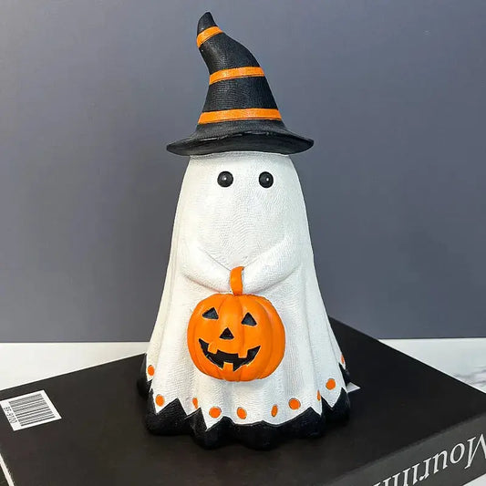 a cake shaped like a ghost with a pumpkin on top of it