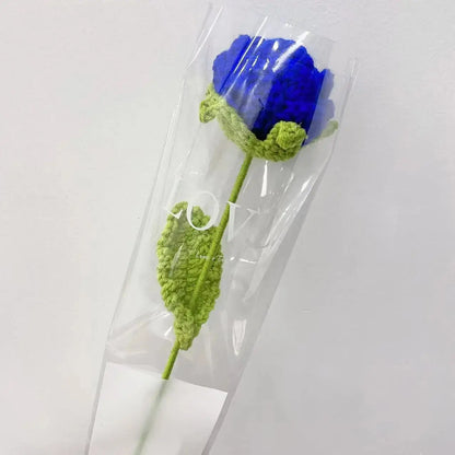 a crocheted blue flower in a clear vase