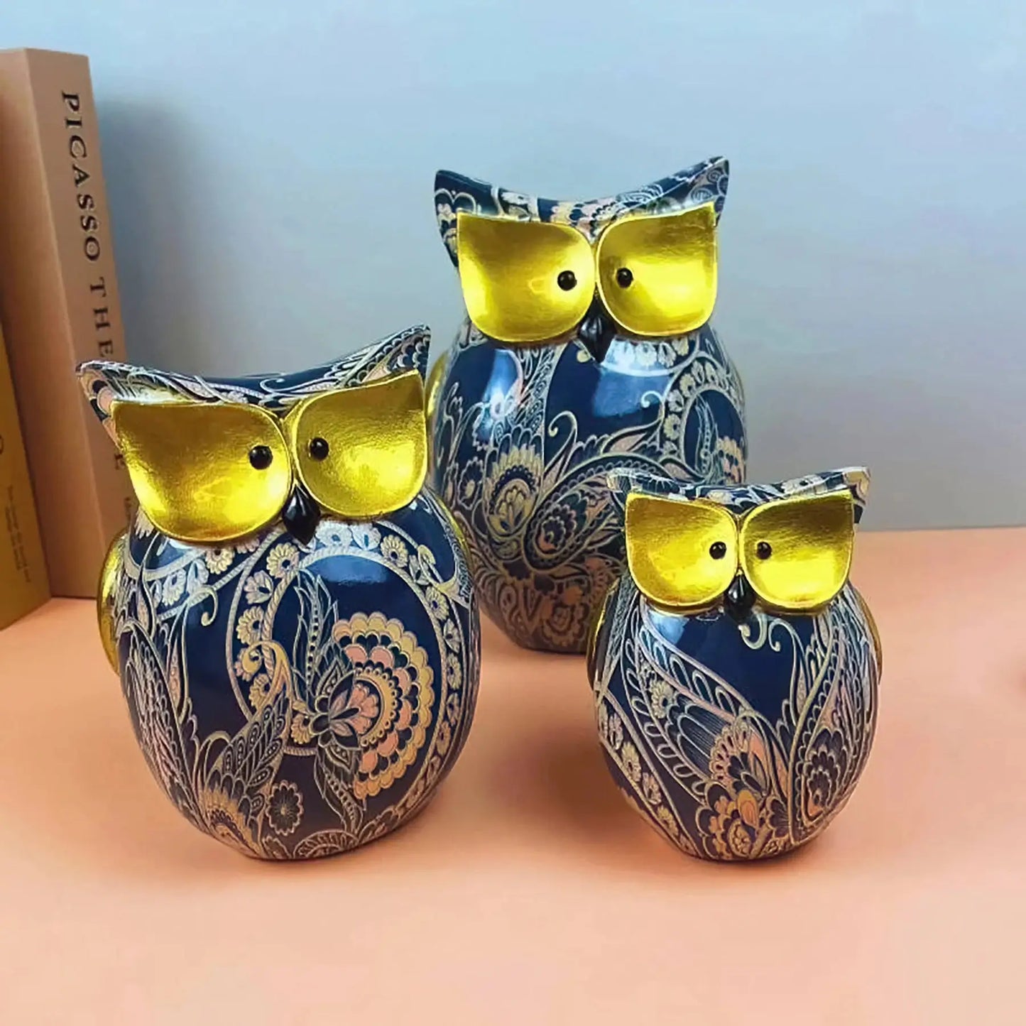 three blue and gold owl shaped vases sitting on a table