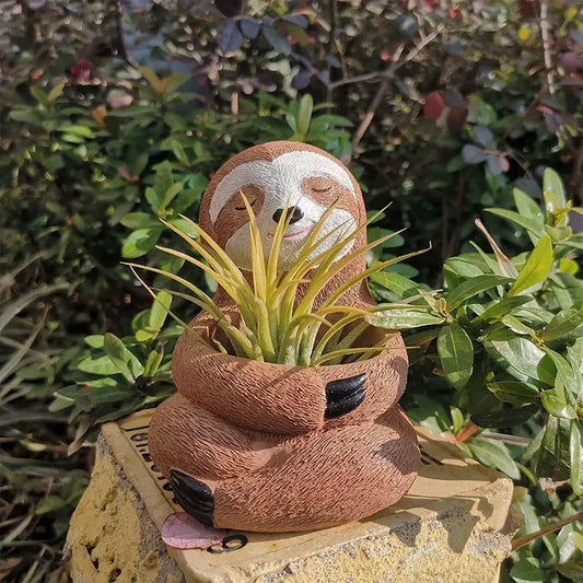 a planter shaped like a sloth with a plant in it