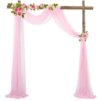 a pink wedding arch decorated with flowers and a cross