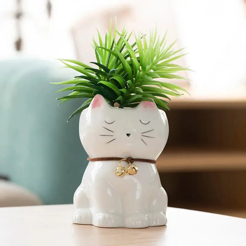 a white cat planter with a green plant in it