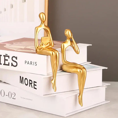 a gold statue sitting on top of a stack of books