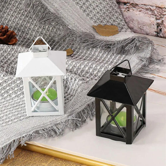 a small lantern sitting on top of a table next to a blanket