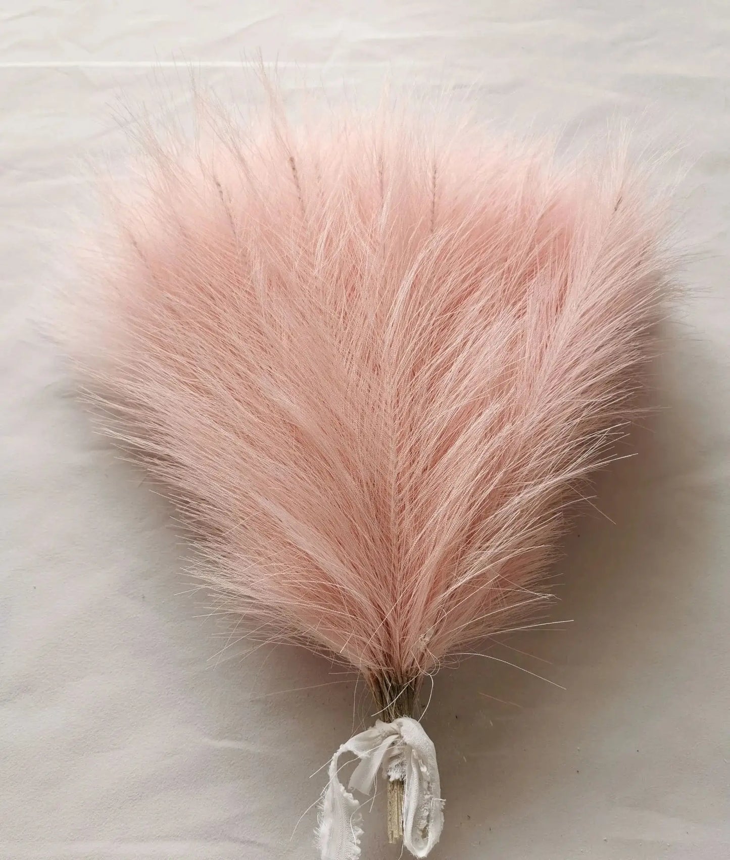a pink furry object on a white surface