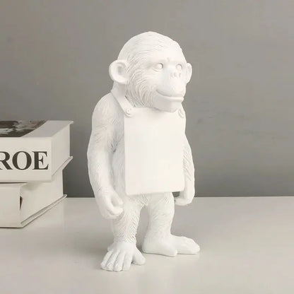 a white statue of a monkey holding a sign