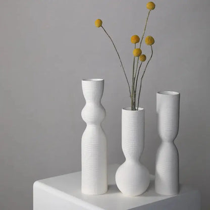 three white vases with yellow flowers in them