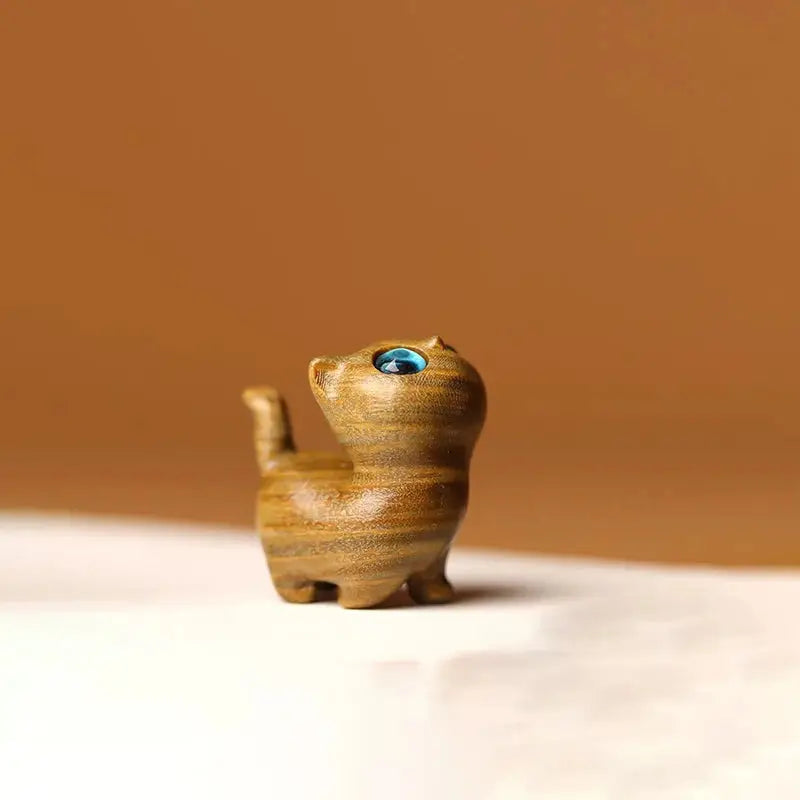 a small wooden toy cat with a blue eye