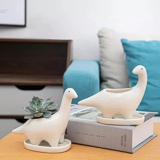 a couple of ceramic birds sitting on top of a book